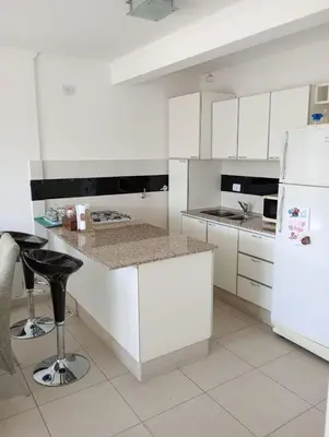 a kitchen with white cabinets and a white refrigerator at Departamento Polanco Tower in Cordoba