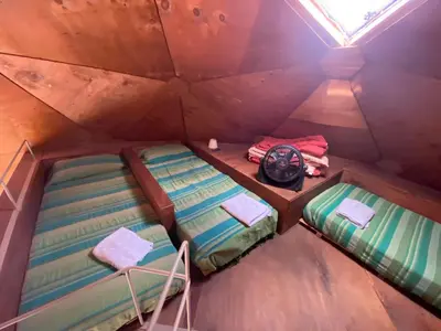 a room with two beds and a clock in it at Domos in Santa Rosa de Calamuchita