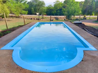 a large blue swimming pool in a yard at Domos in Santa Rosa de Calamuchita