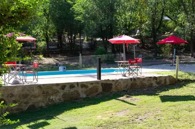 a group of tables and umbrellas next to a pool at Domos in Santa Rosa de Calamuchita