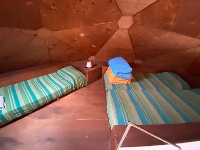an overhead view of two beds in a wooden cabin at Domos in Santa Rosa de Calamuchita