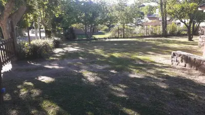 a shady park with a fence and trees at La Casa de la Esquina in Villa Icho Cruz