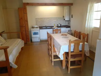 a kitchen with a table and chairs in a room at La Casa de la Esquina in Villa Icho Cruz