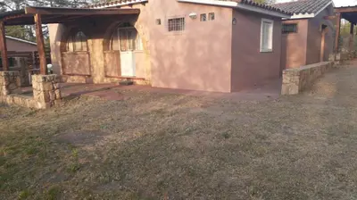 a house with a large door and a yard at La Casa de la Esquina in Villa Icho Cruz