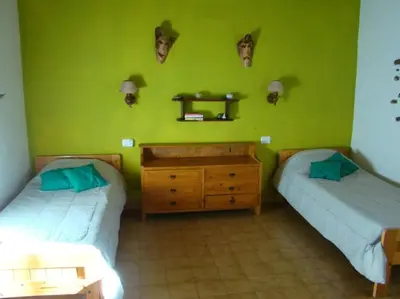 two beds in a room with green walls at Casa Aurelia, San Javier, Córdoba in San Javier
