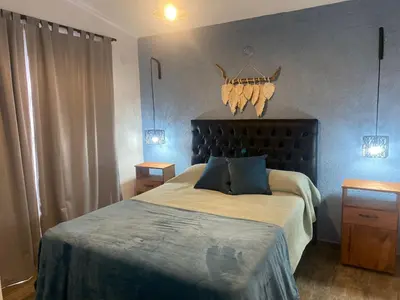a bedroom with a large bed with blue walls at Cabañas Estrellas del Lago in Potrero de Garay