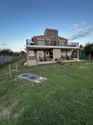 a large house with a grass yard in front of it at Cabañas Estrellas del Lago in Potrero de Garay