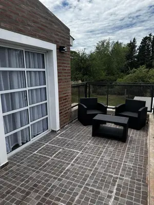 a patio with two chairs and a table and a building at Cabañas Estrellas del Lago in Potrero de Garay