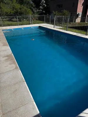 a large blue swimming pool in a yard at Cabañas Estrellas del Lago in Potrero de Garay