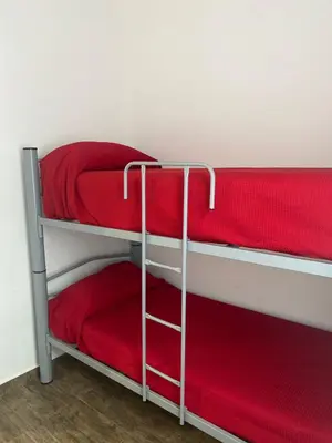 two bunk beds in a room with red sheets at Cabañas Estrellas del Lago in Potrero de Garay