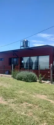 a red house with windows on the side of it at La Casita de Villa Yacanto in Villa Yacanto
