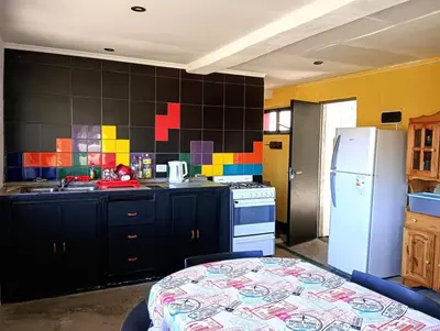 a kitchen with black cabinets and a white refrigerator at La Casita de Villa Yacanto in Villa Yacanto
