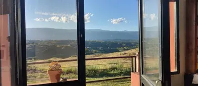 a window with a view of a mountain view at La Casita de Villa Yacanto in Villa Yacanto