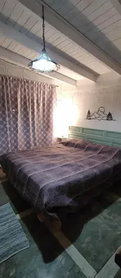 a large bed in a room with a window at La Casita de Villa Yacanto in Villa Yacanto