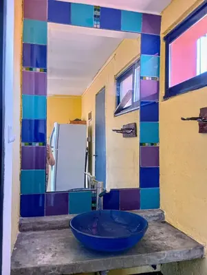 a bathroom with a blue sink and a mirror at La Casita de Villa Yacanto in Villa Yacanto