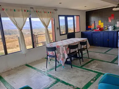 a kitchen with a table and chairs with a view at La Casita de Villa Yacanto in Villa Yacanto