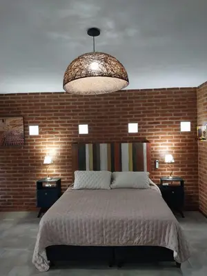 a bedroom with a large bed and a brick wall at soy ahora 1 y 2 in Pueblito