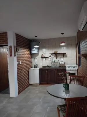 a kitchen with a table and a brick wall at soy ahora 1 y 2 in Pueblito
