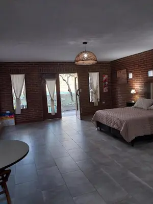 a large bedroom with a bed and a brick wall at soy ahora 1 y 2 in Pueblito