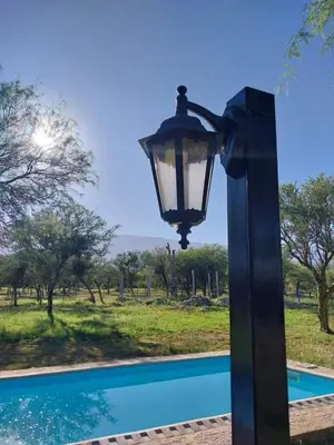 a black lamp post next to a pool at soy ahora 1 y 2 in Pueblito