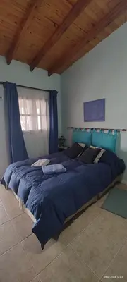 a large bed in a bedroom with blue sheets at La Arcadia in Mina Clavero