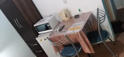 a desk with a microwave and a computer on it at La Arcadia in Mina Clavero
