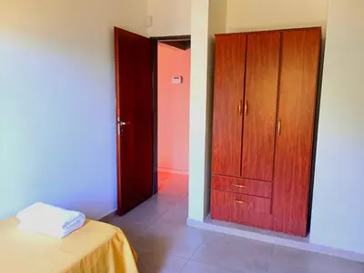 a bedroom with a bed and a wooden closet at Brisas del Lago in La Estancia