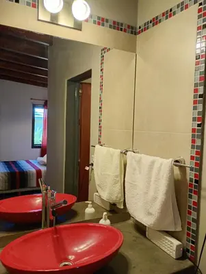 a bathroom with a red sink and a mirror at Brisas del Lago in La Estancia