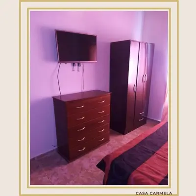 a bedroom with a dresser and a flat screen tv at CasaCarmela8 in Villa Carlos Paz