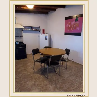 a kitchen with a table and chairs and a refrigerator at CasaCarmela8 in Villa Carlos Paz