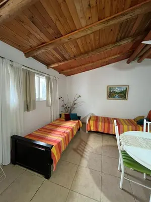 a bedroom with two beds and a wooden ceiling at Cabaña brisas del lago in Villa Parque Siquiman
