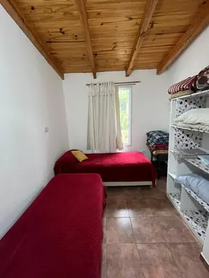 a room with two beds and a window at Cabaña brisas del lago in Villa Parque Siquiman