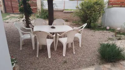 a white table and chairs in a yard at Cabaña brisas del lago in Villa Parque Siquiman