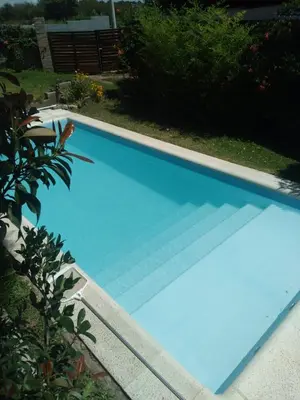 a large blue swimming pool in a yard at Cabaña brisas del lago in Villa Parque Siquiman