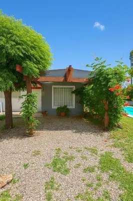 a house with two trees in front of it at Cabaña brisas del lago in Villa Parque Siquiman