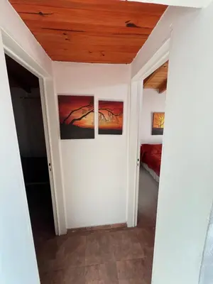 a room with three paintings on the wall at Cabaña brisas del lago in Villa Parque Siquiman