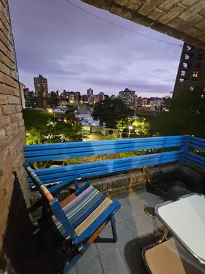 a blue bench sitting on a balcony overlooking a city at En la cañada cerca de todo in Cordoba