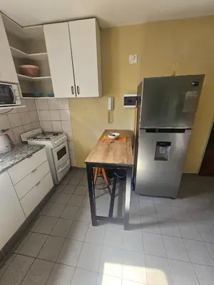 a kitchen with a wooden table and a refrigerator at En la cañada cerca de todo in Cordoba