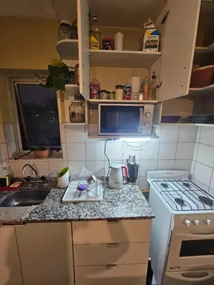 a kitchen with a counter with a sink and a stove at En la cañada cerca de todo in Cordoba
