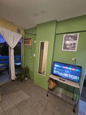 a room with a green wall with a computer on a table at En la cañada cerca de todo in Cordoba