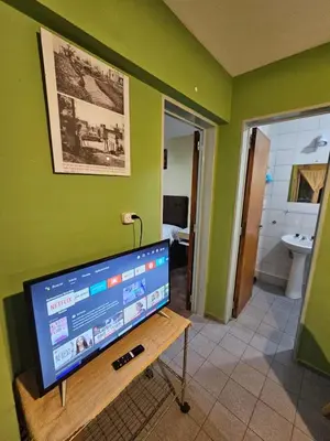 a television on a table in a room with a bathroom at En la cañada cerca de todo in Cordoba