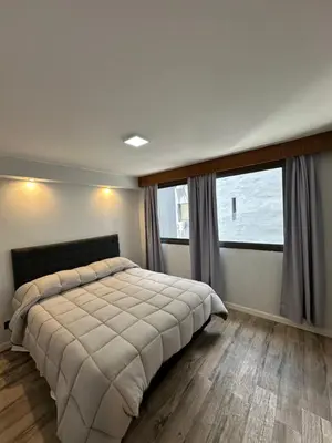 a bedroom with a large bed and large windows at Departamento amoblado 1 dorm con amenities 516 INVERHOME INMOBILIARIA in Cordoba