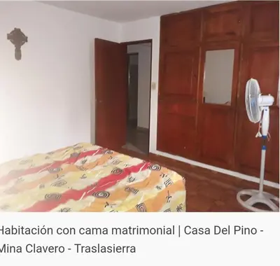 a bedroom with a bed and a fan at Del pino in Mina Clavero