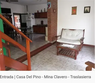 a living room with a chair and a staircase at Del pino in Mina Clavero