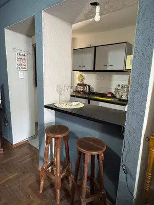 a kitchen with two wooden stools and a counter at LitStay Paraná in Cordoba