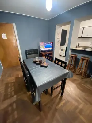 a dining room with a table and chairs and a television at LitStay Paraná in Cordoba