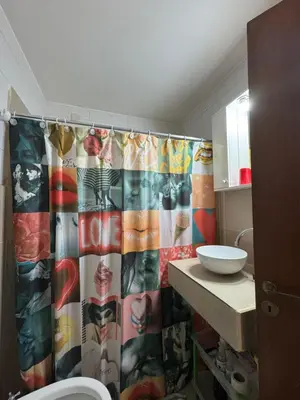 a bathroom with a shower curtain and a sink at LitStay Paraná in Cordoba