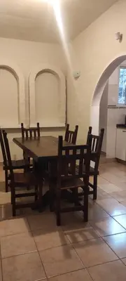 a wooden table and chairs in a room at Complejo Bach in Villa Carlos Paz