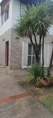 a palm tree in front of a house at Complejo Bach in Villa Carlos Paz