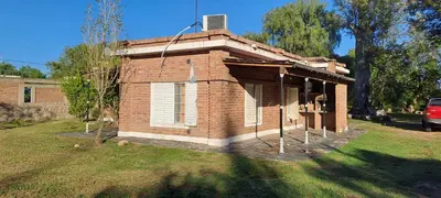a small brick house with a roof on a yard at Posada Los Cerros in Luján